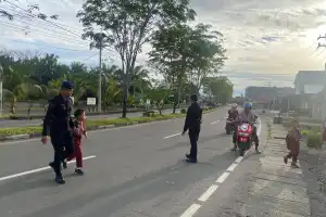 Brimob Batalyon C Pelopor Bantu Anak Sekolah Menyeberang di Nagan Raya