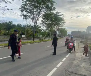Brimob Batalyon C Pelopor Bantu Anak Sekolah Menyeberang di Nagan Raya
